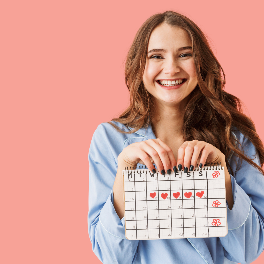 Woman holding a calendar that shows she is tracking her menstrual cycle